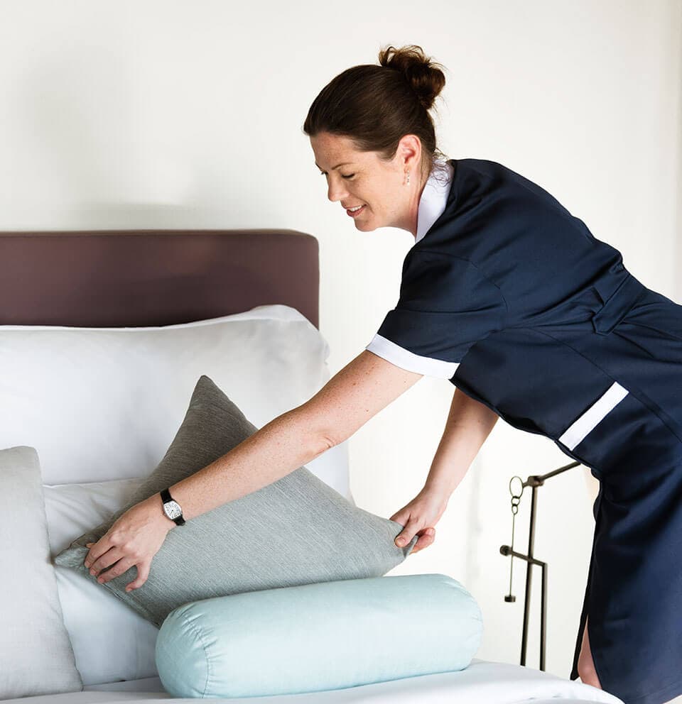 Professional cleaner making a bed